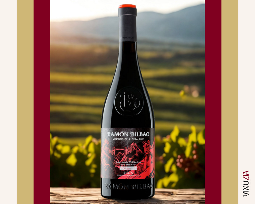 Botella Ramón Bilbao Viñedos de Altura frente a viñedo iluminado por el sol, con fondo montañoso y estilo natural. Imagen con sello Vinozia.